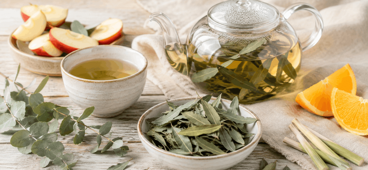 BIO Eukalyptusblätter als Tee: fruchtige Ideen für warme und kalte Aufgüsse 1 Geschnittene BIO Eukalyptusblätter von OmVeda mit Teekanne, Tasse, Orange, Apfel und Zitronengras